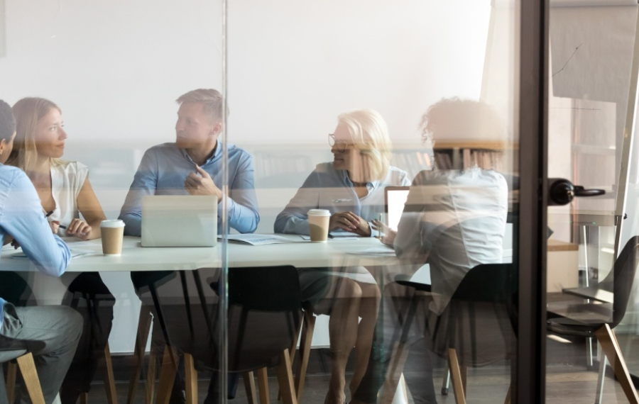 A procurement team meeting in a glass-walled boardroom